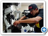 Undergrad Keith Thunder placing a green algae sample on the hyperspectral microscope (Lidke)