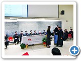Regent's Lecturer and Associate Professor Dinesh Loomba places the doctoral hood over PhD graduate Nguyen Phan's head
