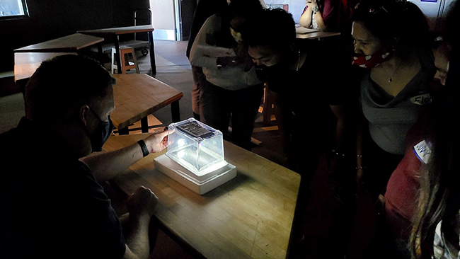 Teachers participate in a real-time experiment viewing particle tracks created in a portable cloud chamber detector.